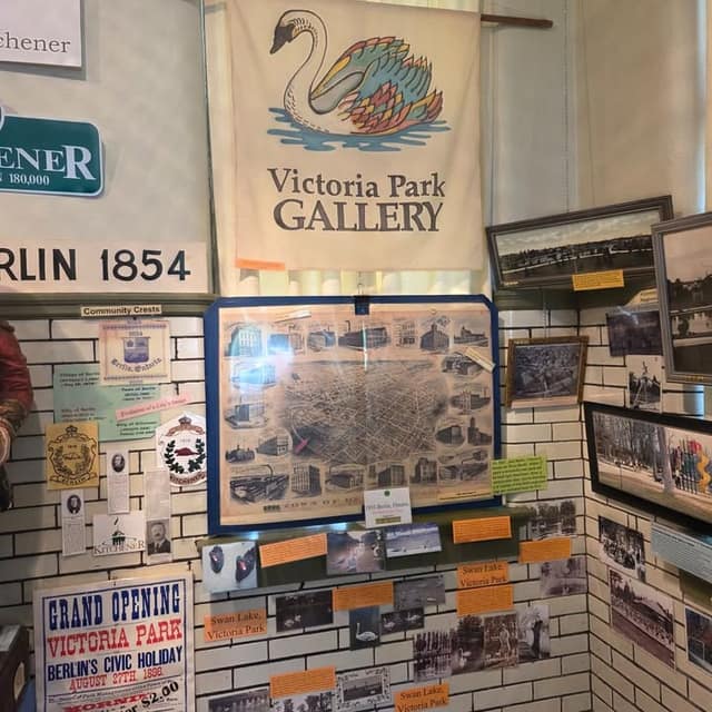 Gallery corner with a swan banner reading Victoria Park Gallery, a Berlin map, community crests, and a Grand Opening poster from 1896.
