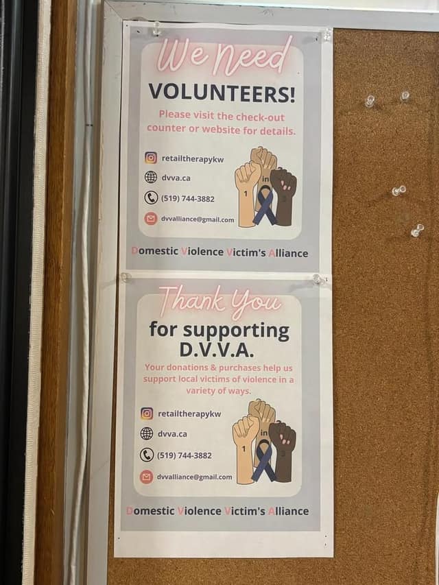 Two posters on a corkboard read "We Need Volunteers!" and "Thank You for supporting D.V.V.A." with contact details and raised fists.