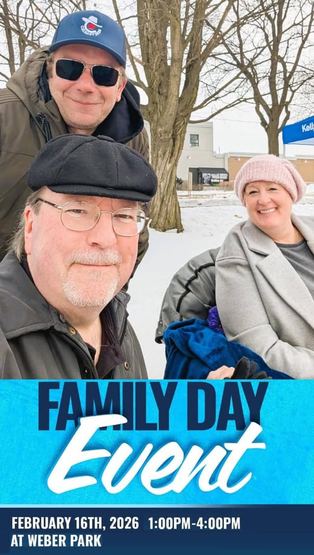 A man in a flat cap, a man in a blue cap and sunglasses, and a smiling woman in a pink toque pose outdoors in snow.