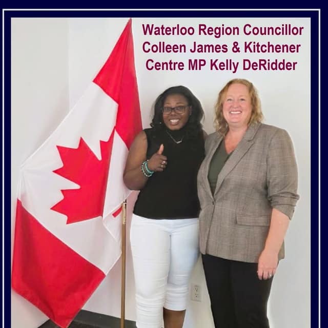 Kelly DeRidder stands smiling beside Waterloo Region Councillor Colleen James, who gives a thumbs-up, next to a Canadian flag.