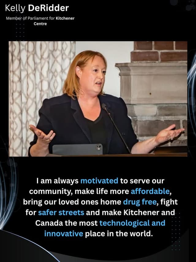 Kelly DeRidder speaks at a podium microphone with both hands open, in front of a stone fireplace and patterned curtains.